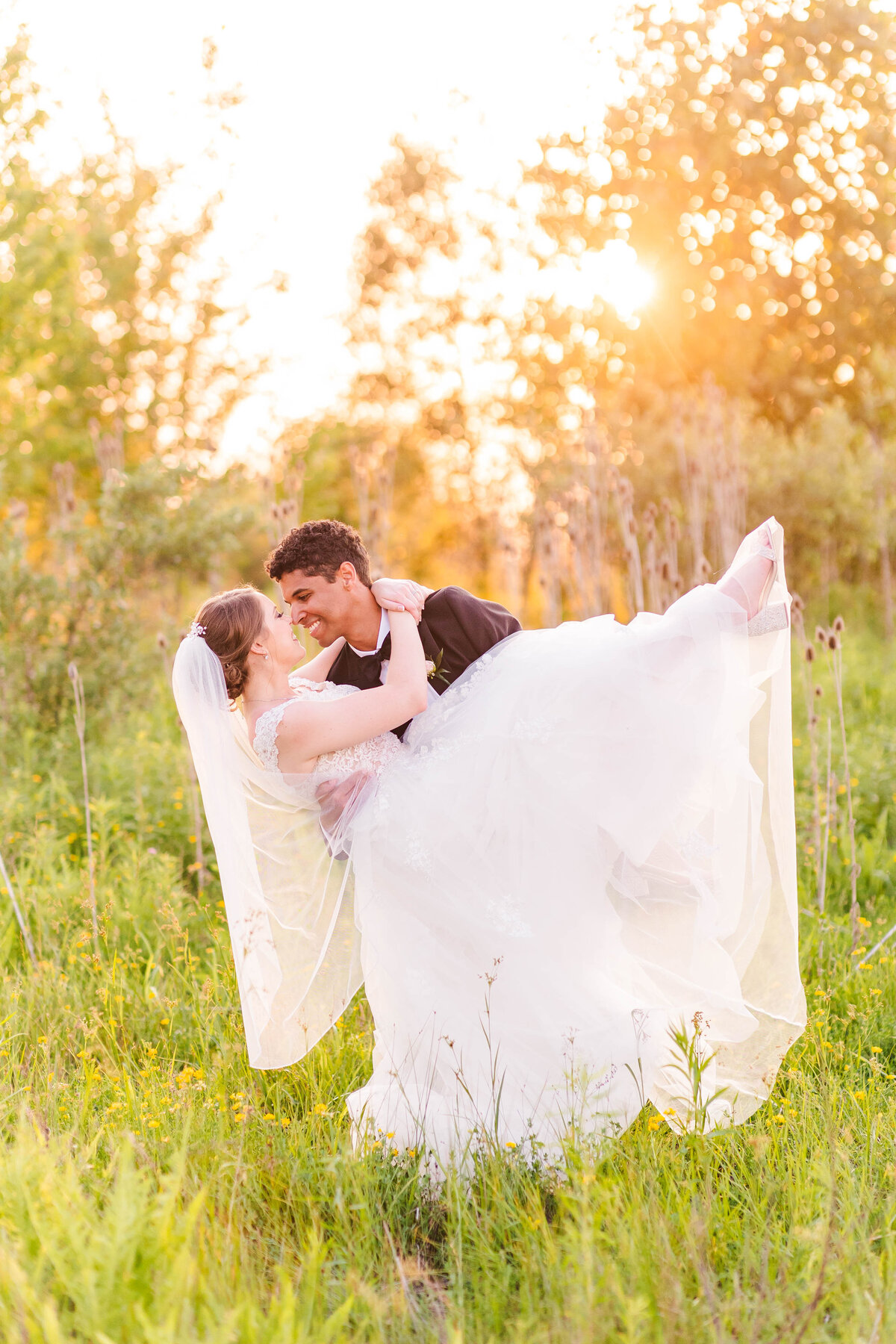 Bride and groom walking through tall grass