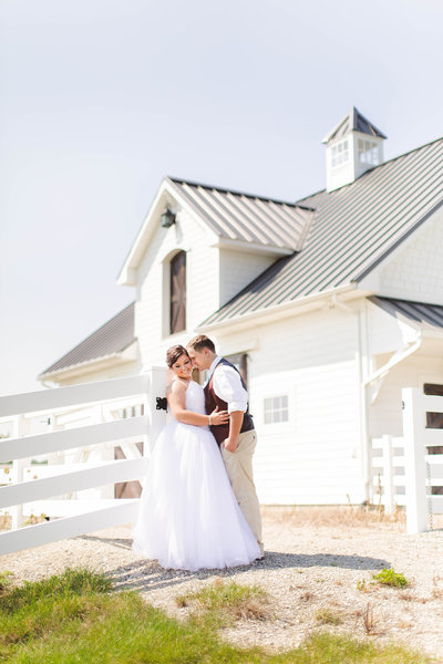 Wedding couple near a white barn